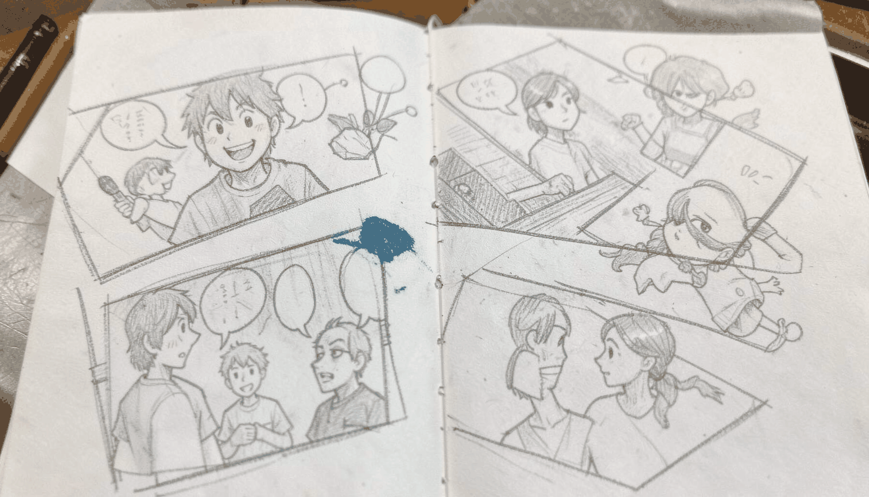 Graphite pencil sketch of several small comic strip panels scattered across a desk, with speech bubbles and quick character doodles in soft grey tones